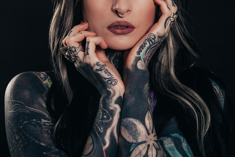 close up of a a heavily tattooed woman with a septum piercing