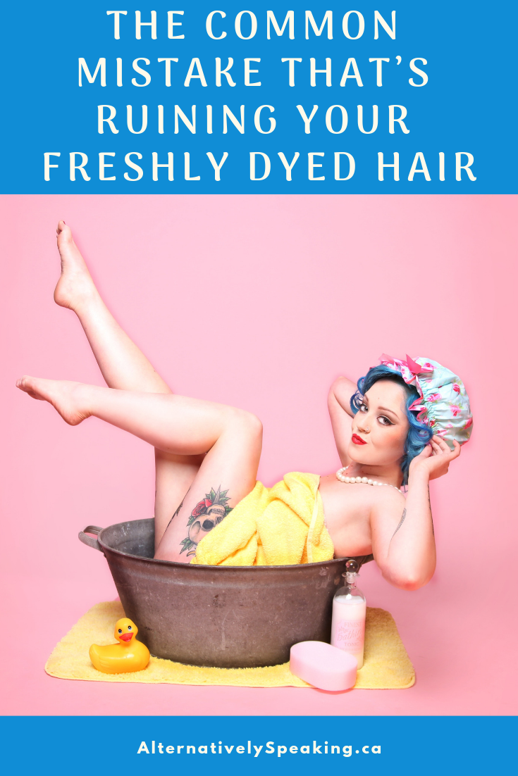 pinterest image showing a woman sitting in a washing tub, wrapped in a towel with blue hair, says 'the common mistake that's ruining your freshly dyed hair'
