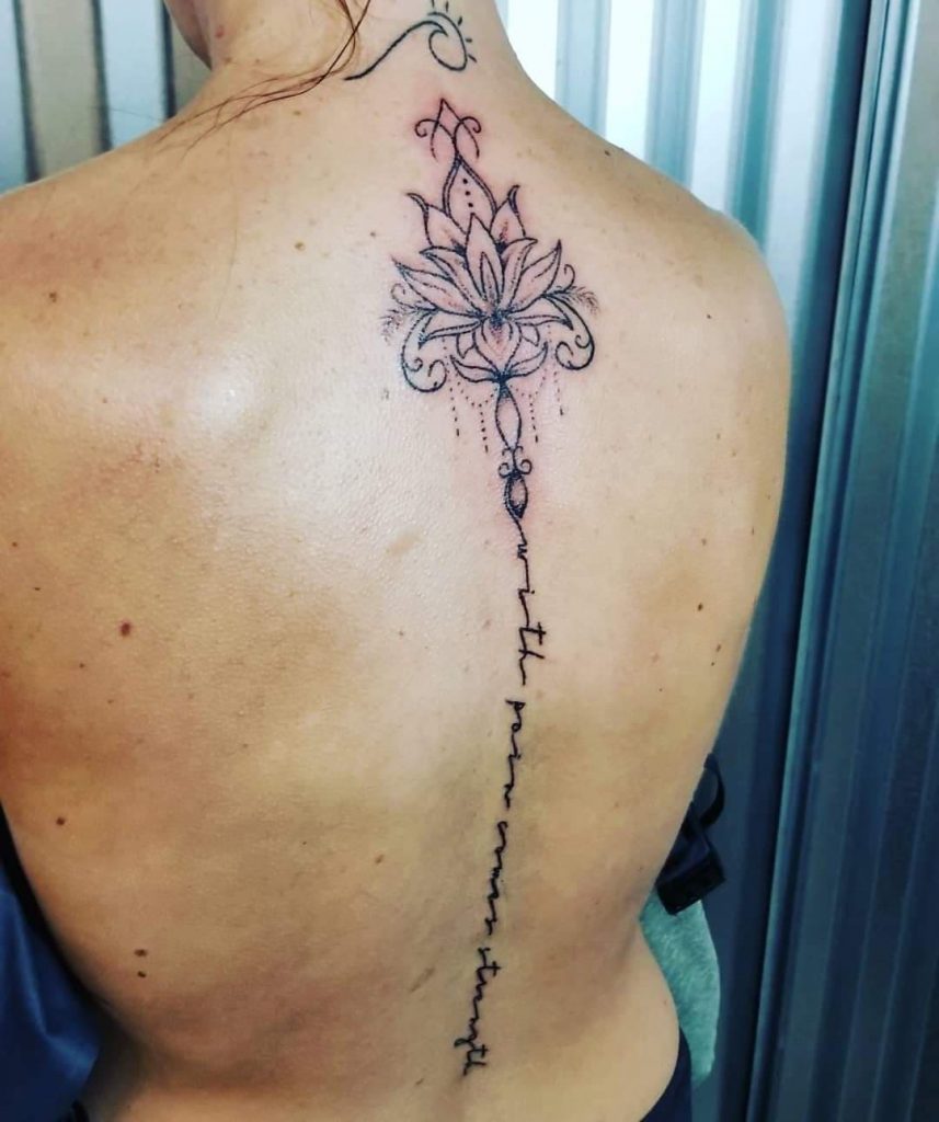 hand poke tattoo of a flower running along the spine in black ink