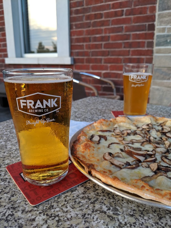 beer in Frank Brewing Co. glasses next to a pizza