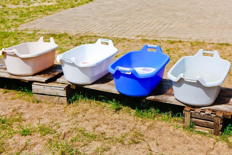 line of wash basins sitting outside full of greywater