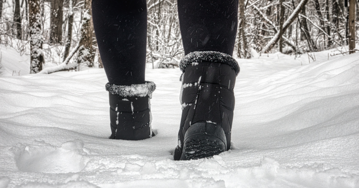 photo of a woman walking through snow in winter boots