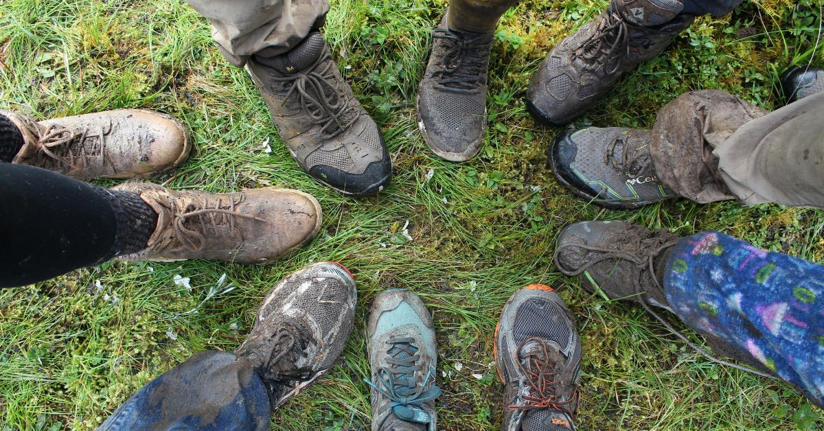 circle of dirty boots and shoes on the grass